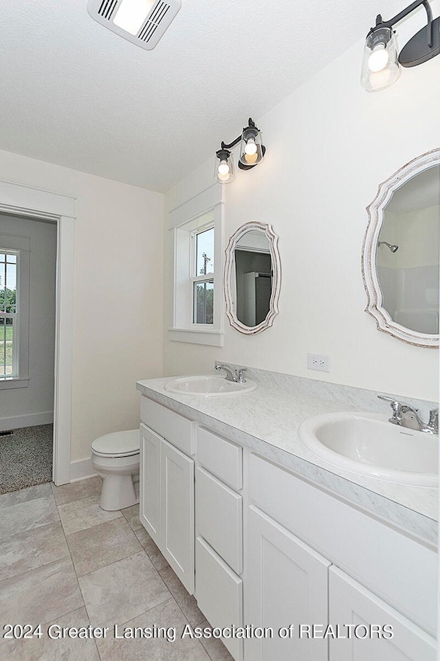 bathroom with a shower, a textured ceiling, toilet, and vanity