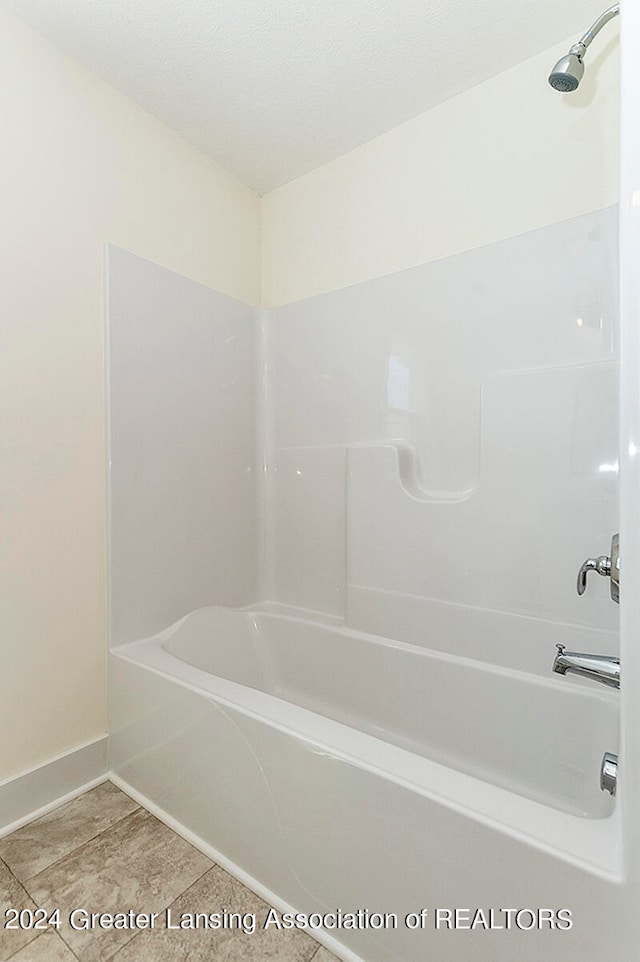 bathroom featuring tile patterned flooring and  shower combination