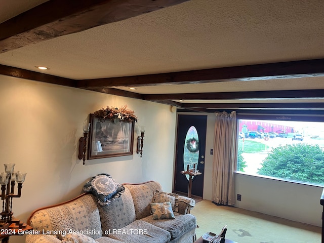 carpeted living room with beamed ceiling and a textured ceiling