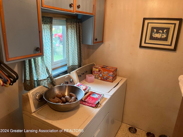 washroom featuring washer and dryer, cabinets, and tile patterned flooring