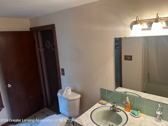 bathroom with toilet, tasteful backsplash, and vanity