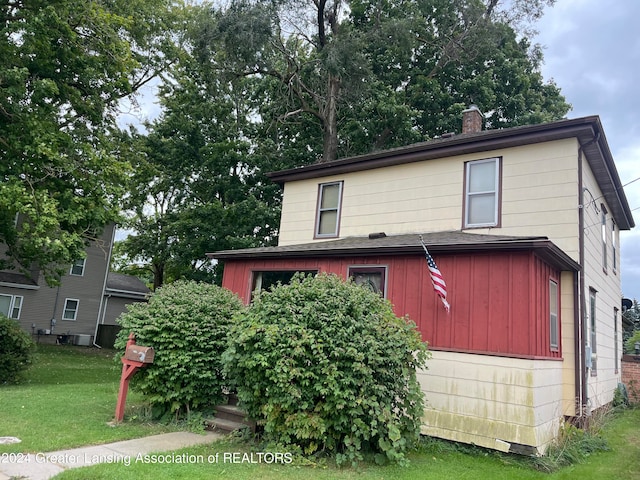 view of front of home featuring central air condition unit and a front yard