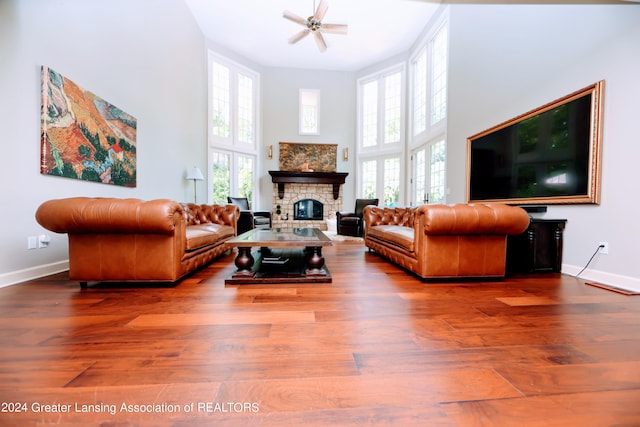 living room with hardwood / wood-style floors, a healthy amount of sunlight, and a high ceiling