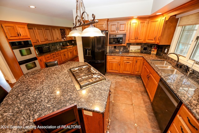 kitchen with sink, tasteful backsplash, dark stone countertops, decorative light fixtures, and black appliances