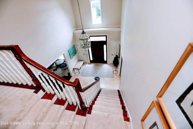 foyer with a high ceiling, light hardwood / wood-style floors, and an inviting chandelier