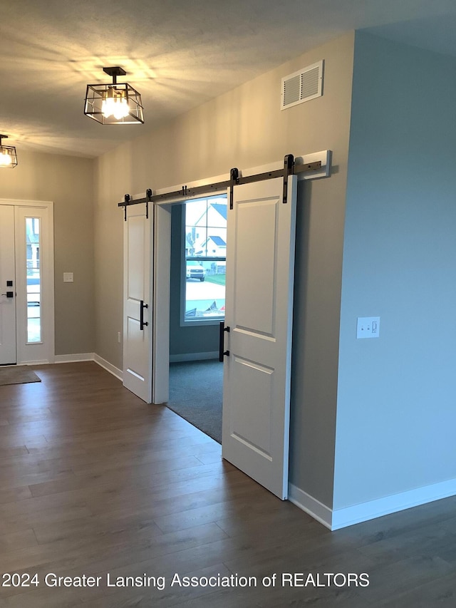 entrance foyer with a barn door and dark hardwood / wood-style floors