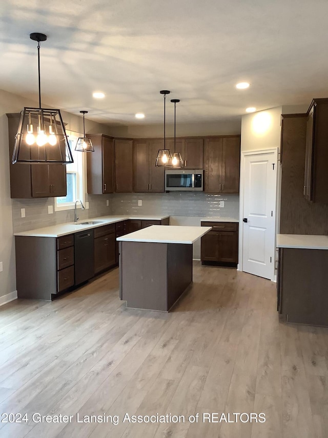 kitchen featuring dishwasher, hanging light fixtures, a kitchen island, light hardwood / wood-style floors, and dark brown cabinetry