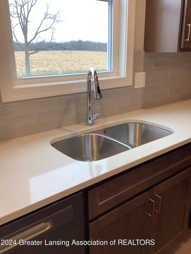 room details featuring dishwasher, dark brown cabinetry, tasteful backsplash, and sink