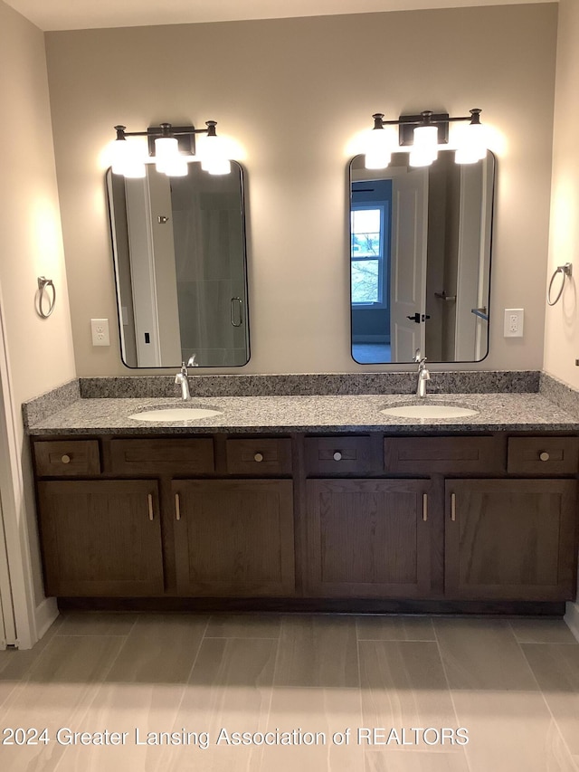 bathroom with tile patterned floors, a shower with door, and vanity