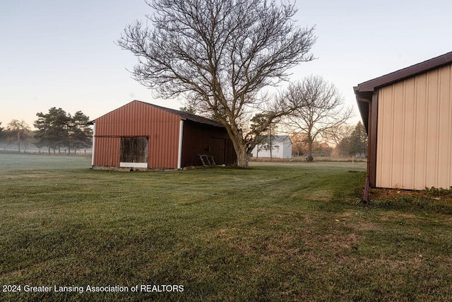 yard at dusk featuring an outdoor structure