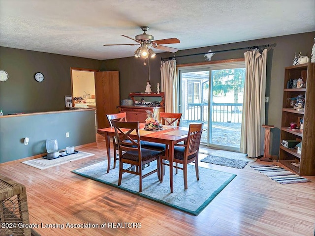 dining space with ceiling fan, light hardwood / wood-style flooring, and a textured ceiling