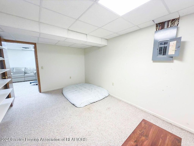 carpeted bedroom with a paneled ceiling and electric panel