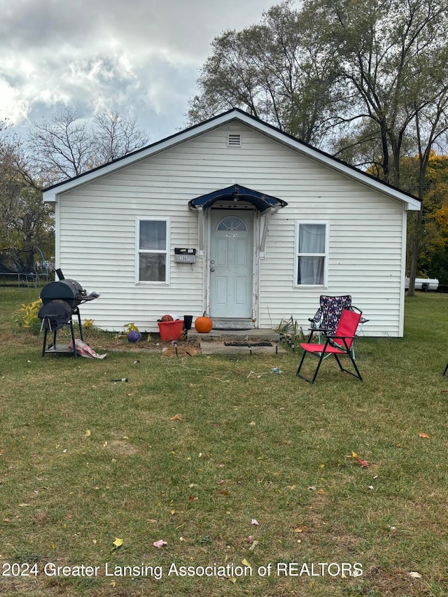 rear view of house featuring a yard