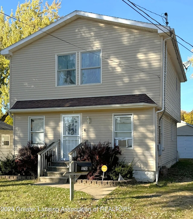 view of front facade with cooling unit, a front lawn, and a garage