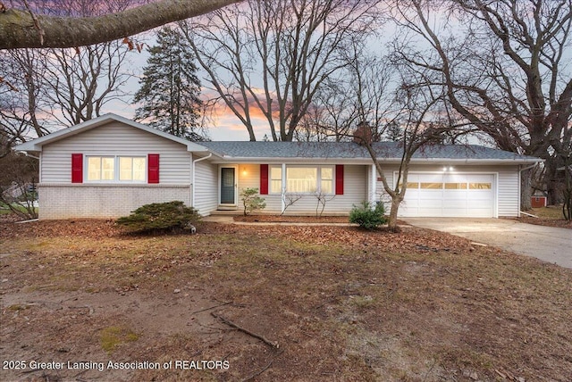 ranch-style house with a garage, driveway, and brick siding