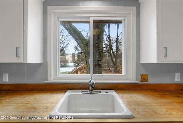 details with white cabinetry, light countertops, and a sink