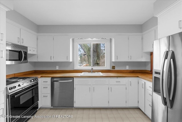 kitchen featuring stainless steel appliances, white cabinets, and a sink