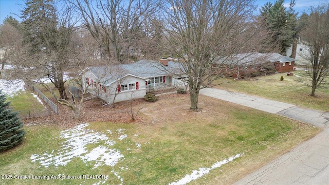 single story home featuring driveway, a chimney, a front yard, and fence