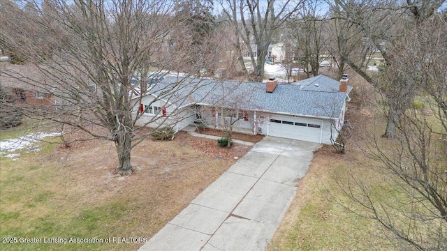 view of front facade with a garage, concrete driveway, and a chimney