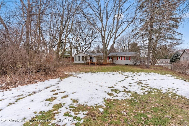 ranch-style home featuring a deck and fence