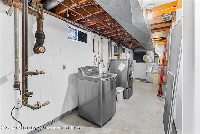 washroom with laundry area, washer and clothes dryer, and heating unit