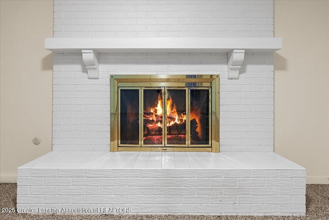 room details featuring a brick fireplace and carpet flooring