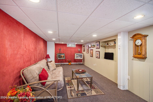 living room with a drop ceiling and carpet flooring