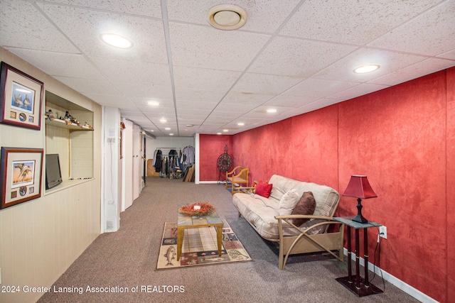 living room with a paneled ceiling and carpet