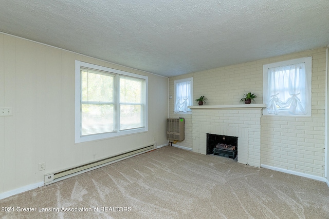 unfurnished living room featuring a textured ceiling, a baseboard heating unit, a brick fireplace, and light colored carpet