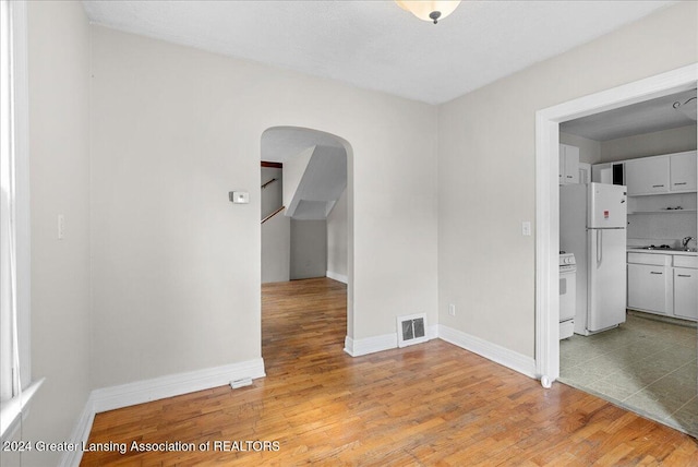 spare room with light hardwood / wood-style floors and sink