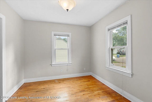 unfurnished room featuring light hardwood / wood-style floors and plenty of natural light