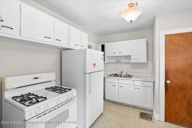 kitchen with white appliances, sink, and white cabinets