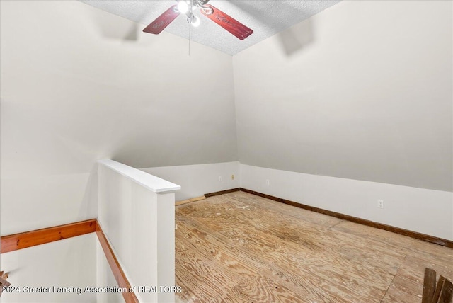 unfurnished room with hardwood / wood-style floors, ceiling fan, a textured ceiling, and vaulted ceiling