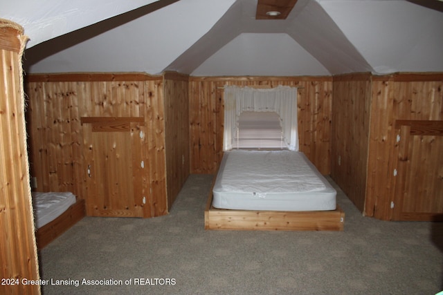 unfurnished bedroom featuring lofted ceiling, wood walls, and light colored carpet