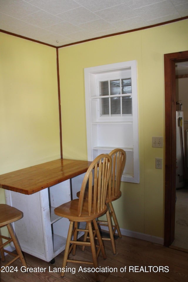 dining space featuring wood finished floors and ornamental molding