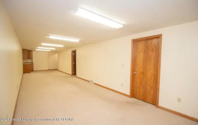 basement featuring light carpet