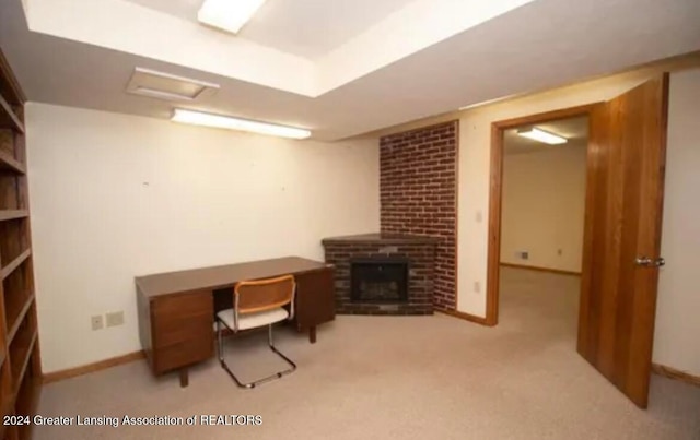 carpeted home office featuring a fireplace