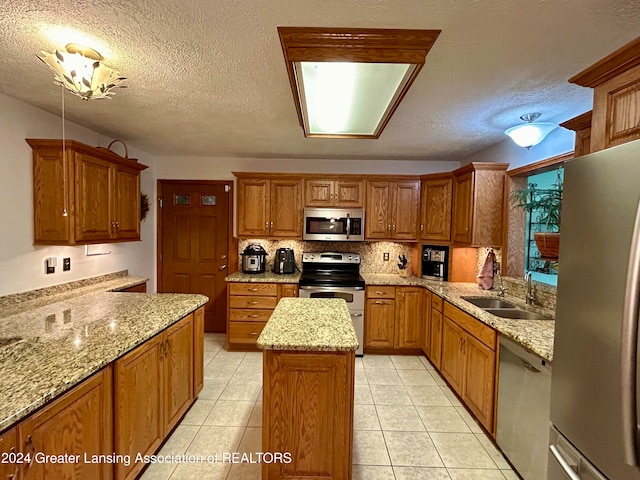 kitchen featuring appliances with stainless steel finishes, a textured ceiling, and a center island