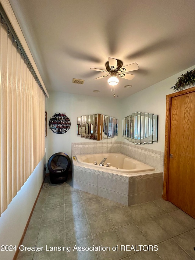 bathroom with ceiling fan, a relaxing tiled tub, and tile patterned flooring