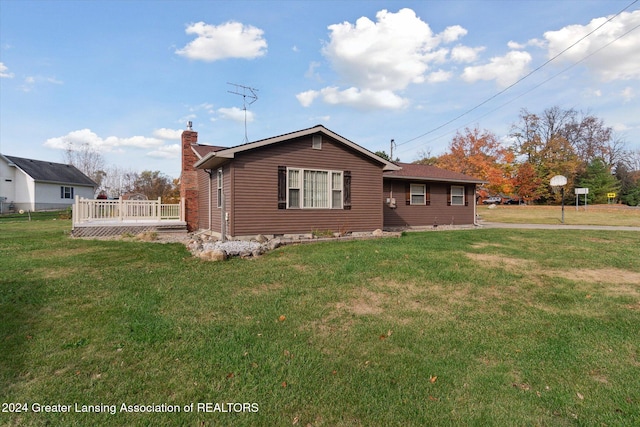 view of side of home with a deck and a yard