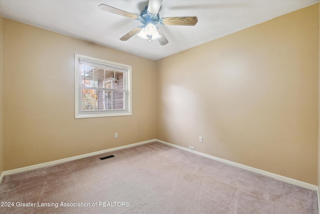 carpeted spare room featuring ceiling fan