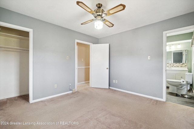 unfurnished bedroom featuring connected bathroom, light colored carpet, a closet, and ceiling fan