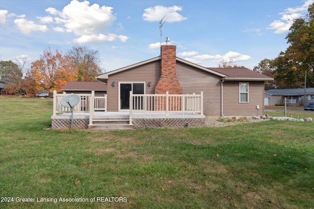 rear view of house featuring a yard and a deck