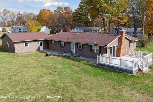 back of property with a wooden deck and a lawn