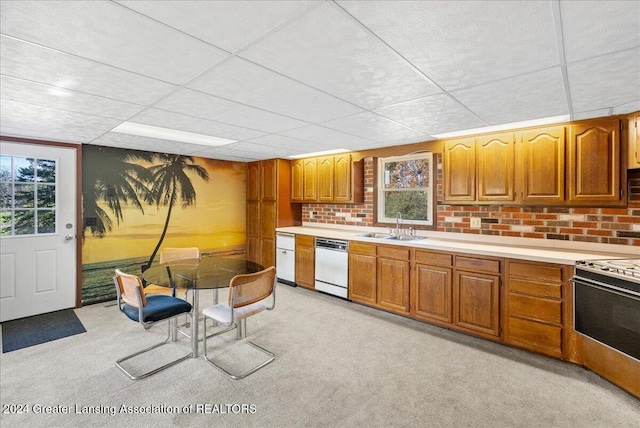 kitchen featuring sink, a drop ceiling, electric range oven, white dishwasher, and light colored carpet