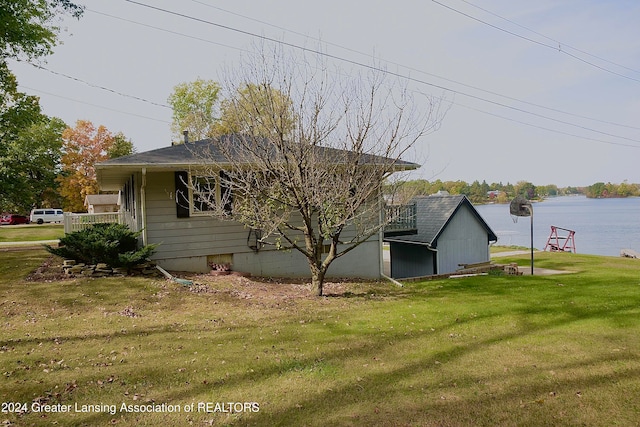 view of side of property with a yard and a water view