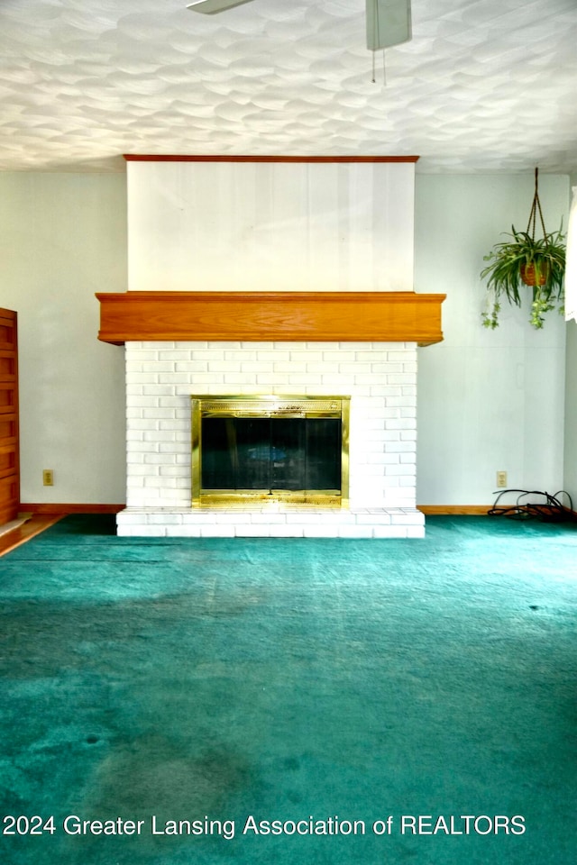 unfurnished living room featuring a textured ceiling, carpet flooring, and a fireplace