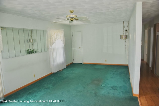 empty room with dark wood-type flooring and ceiling fan