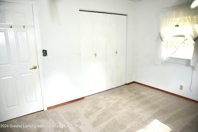 unfurnished bedroom with a closet and carpet floors