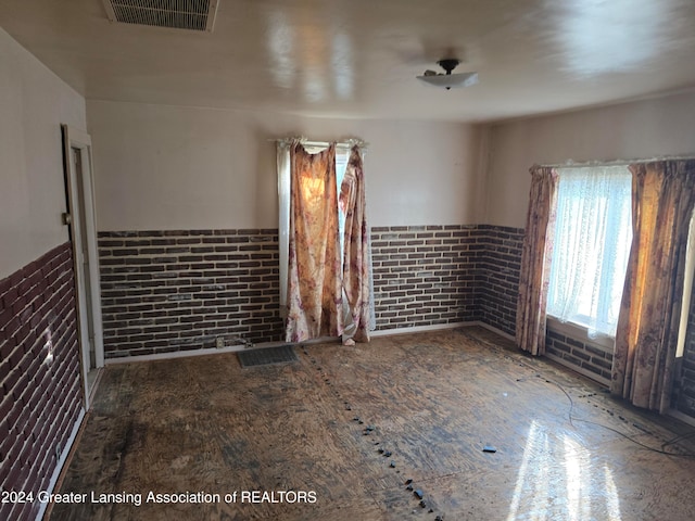 unfurnished room with brick wall